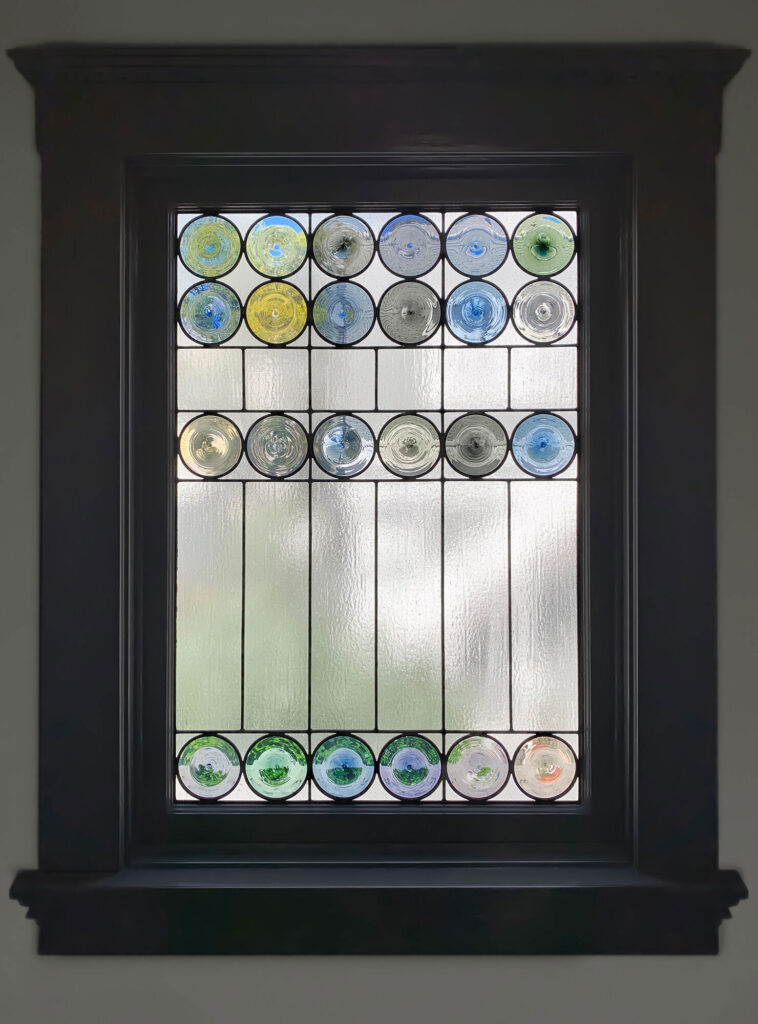 Rondel stained glass window in window frame